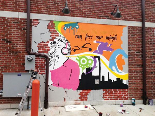 Natal was commissioned to design and paint a mural, located on the back of the new Dunkin’ Donuts building on Martin Luther King Blvd. Photo from Twitter